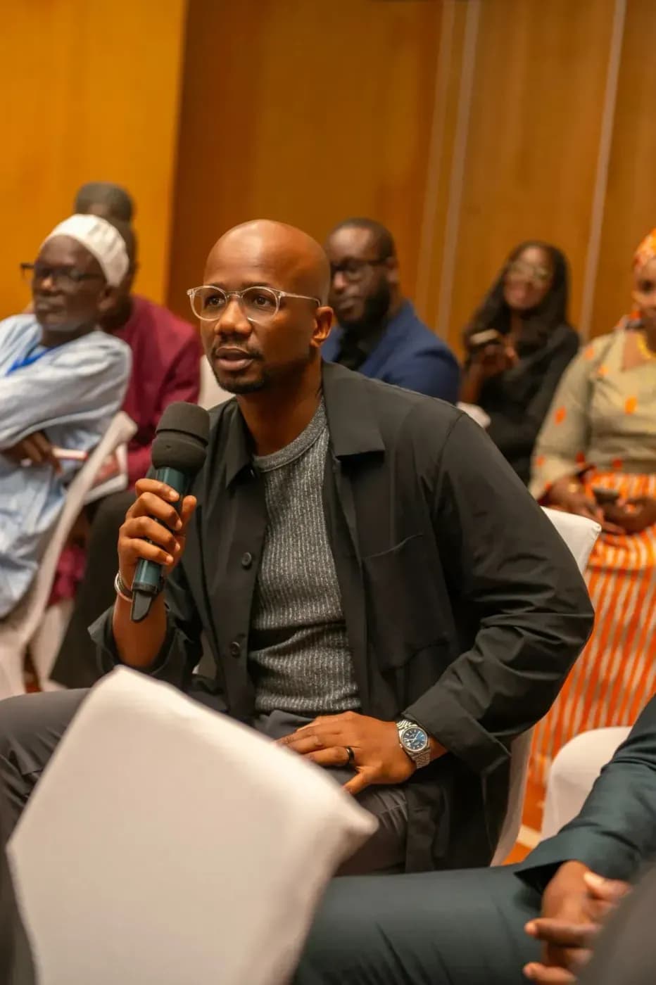 A standing attendee asks a question at the microphone