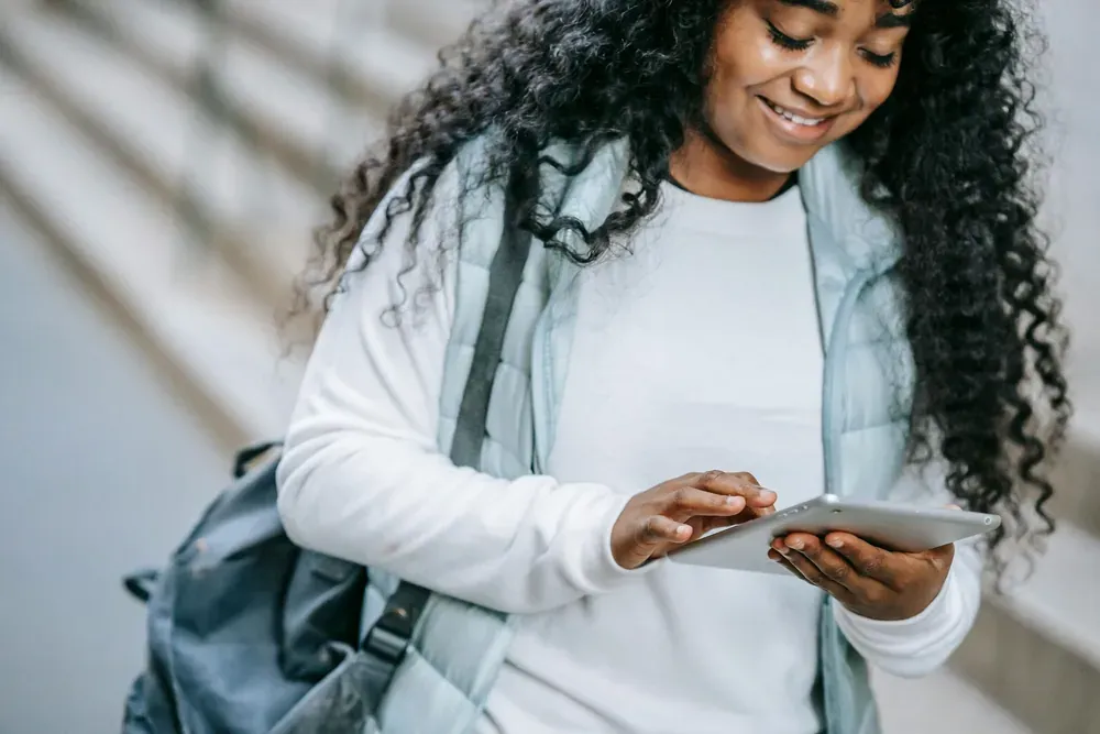 A student checking her tablet on campus